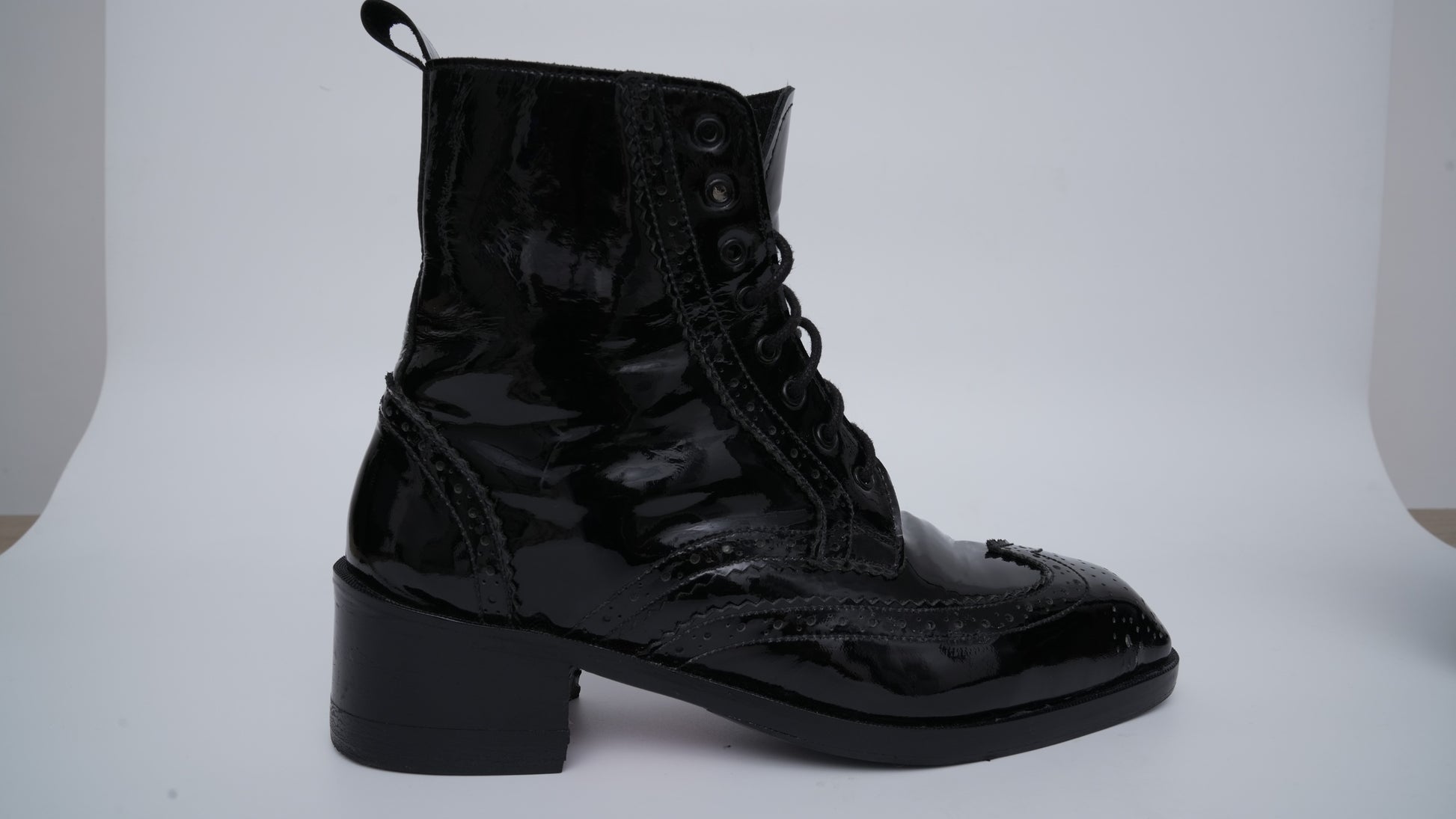 Black lace-up boot on a white background